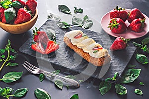 French eclair grazed with chocolate and fruity strawberry cream or sweet Italian profiteroles and fresh juicy strawberries, food