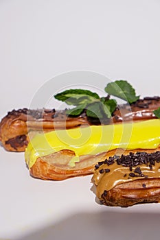 French eclairs with choclate top and different fillings. Traditional recipe, French cuisine.