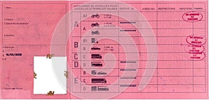 A french / european driving license, inside page with description of permitted driving vehicles, red, with passing stamps
