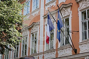 French flag next to the EU flag on a historic building