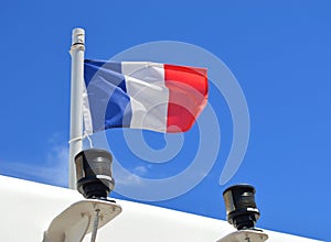 French flag on ship against a blue sky.