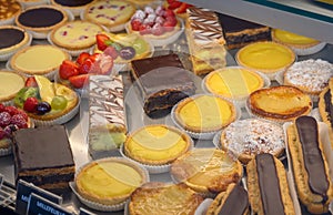French fresh baked sweet pastry with chocolate, fresh fruits and berries in confectionery shop close up
