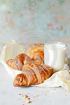 French fresh crispy croissant with a glass of milk for breakfast, selective focus