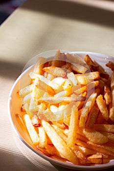 French fried in white bowl on table, close up food photo