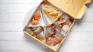 French Fries or Chips and chicken wings in a takeaway packet