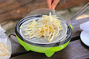 French fries cooking on deep fryer.