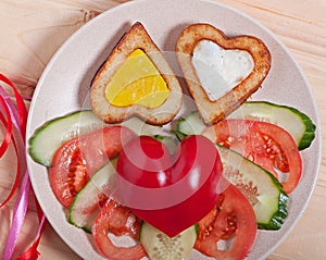 French fries and fresh vegetables chopped in the shape of a heart.