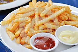 French fries or fried potato with tomato sauce and mayonnaise