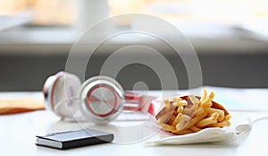 French fries with headphones lying on