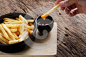 French fries with ketchup on a dark wood . fastfood snack