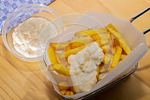 French fries in a metal basket and mayonnaise in a glass bowl