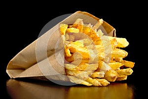 French fries in the paper bag isolated on black