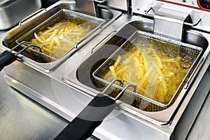 French fries or potato chips frying in oil