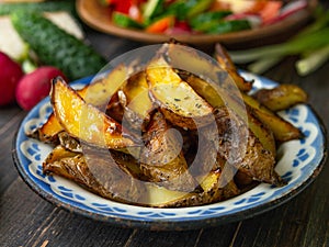 French fries, salad, vegetables on an old wooden background. Rural dinner, summer picnic. Close up