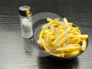 French fries and salt shaker on the table.