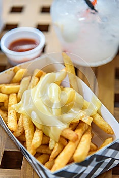 French Fries on Toping Cheese in Paper Box.