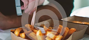 French fries on tracing paper on board on wooden table