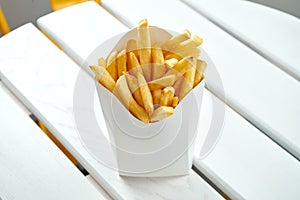 French fries in a white delivery box on a white background. American fast food. Food delivery