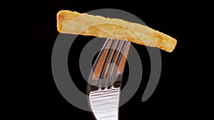 French fry on a fork rotate and gets stripe of ketchup