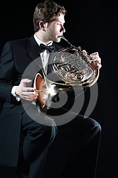 French horn player. Classical orchestra musicians playing brass instruments
