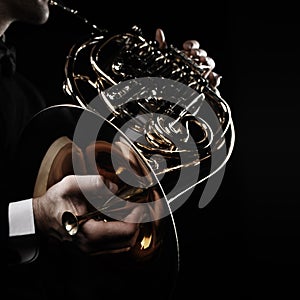 French horn player hands playing brass instrument