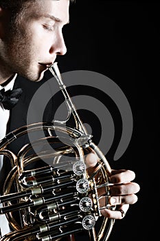 French horn player. Hornist playing brass instrument