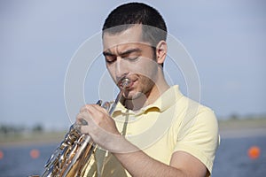 French horn player playing music instrument Man hornist classical musician