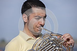 French horn player playing music instrument Man hornist classical musician