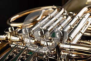 French horn on a wooden table. Beautiful polished musical instrument