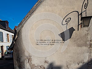 A french literature quote written on a blind wall of a old house