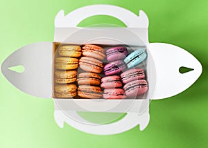 French macarons in a box over a green background