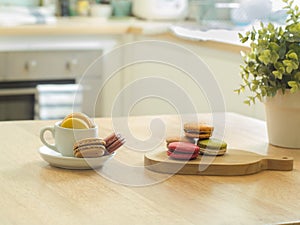 French macarons in cup and wooden tray on wooden table