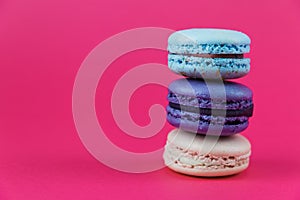 French macarons. Sweet colorful bisquits. Front view. Copy text space. Hot pink background.