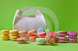 French macarons and a white box over a green background