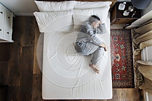 French man sleeping alone on bed