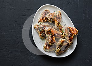French mustard marinade roasted chicken wings - delicious appetizers, tapas on dark background, top view
