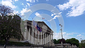 French National Assembly building with French and EU flags waving - Paris