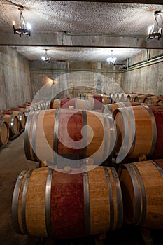 French oak wooden barrels for aging red wine in underground cellar, Saint-Emilion wine making region picking, cru class Merlot or