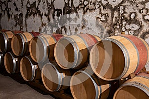 French oak wooden barrels for aging red wine in underground cellar, Saint-Emilion wine making region picking, cru class Merlot or