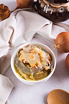 French onion soup with baked cheese bread in a bowl on the table vertical view