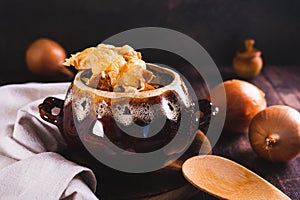 French onion soup with melted cheese and croutons in a pot on the table