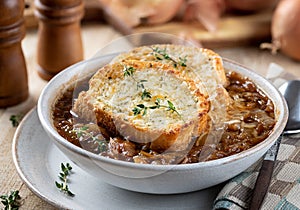 French onion soup with toasted cheese baguette garnished with thyme
