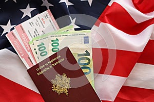 French passport and euro money with airline tickets on United States national flag background