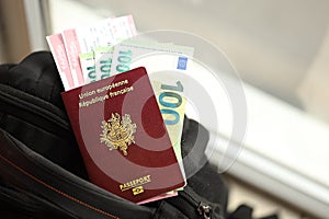 French passport and euro money bills with airline tickets on backpack