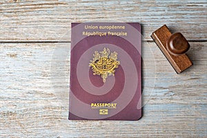 French passport and stamp on wooden background. Safe journey with necessary documentation. Top view. Copy space
