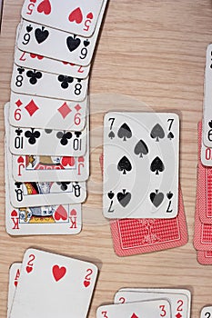 French playing cards stacked together in a solitaire. Solitaire game with cards, pastime with signs and cards with red backs and