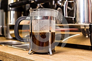 French press coffee pot on table.