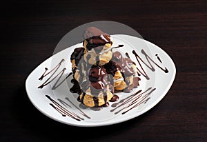 French profiterole with chocolate icing on a plate