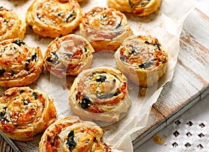French Puff Pastry Pinwheels stuffed with salmon, cheese and spinach on on baking paper