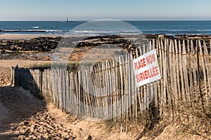 French sign Unguarded beach on wood fence